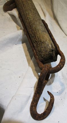 an old wooden bench with metal chains hanging from it's back end on a white sheet