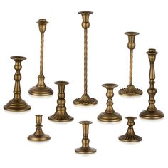 an assortment of candlesticks and candle holders