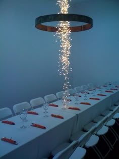 a long table is set with white linens and silverware