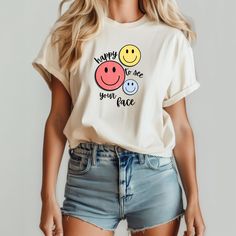 A cheerful and fun graphic T-shirt featuring a smiley face design, perfect for teachers or anyone who wants to spread positive vibes. This tee is made with lightweight cotton, making it ideal for everyday wear and layering. The retail fit and classic crew neckline add a neat and versatile style that can easily be accessorized. Great for casual and semi-formal settings, this tee is a must-have for those looking to add a touch of happiness to their wardrobe. Product features - Lightweight 100% Air Playful White T-shirt With Smiley Face, Fun Cotton T-shirt With Smiley Face, Playful White Top With Smiley Face, Fun Slogan T-shirt For Everyday, White Playful T-shirt With Smiley Face, Playful Relaxed Fit T-shirt With Text Print, White Smiley Face T-shirt, Funny Smiley Face T-shirt For Summer, Funny Graphic Print Tops For Everyday