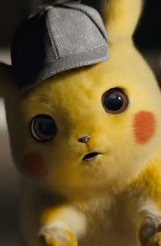 a yellow stuffed animal with big eyes and a hat on top of it's head