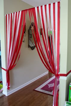 a red and white drape with scissors hanging from it's sides on a wall