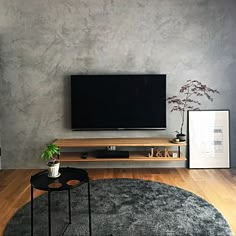 a living room with a large flat screen tv mounted on the wall above a black coffee table