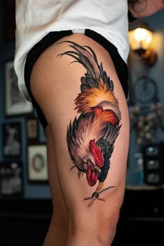 a rooster tattoo on the back of a woman's thigh