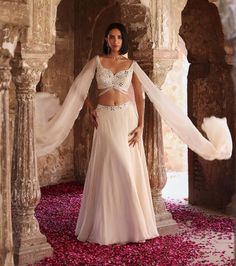 Indulge in sophistication with this embellished choli featuring attached flared sleeves, perfectly paired with a circular skirt adorned with an embellished belt and can-can detailing. This ensemble epitomizes elegance, offering a seamless blend of traditional charm and contemporary flair. Make a statement at any event or celebration with this exquisite outfit that exudes grace and style. Traditional Fitted Lehenga With Draped Sleeves, Wedding Lehenga With Draped Sleeves And Floor-length, Floor-length Lehenga With Draped Sleeves For Reception, Traditional Draped Sleeves Choli For Wedding, Bollywood Lehenga With Draped Sleeves For Reception, Designer Fitted Lehenga With Draped Sleeves, Designer Wear Fitted Lehenga With Draped Sleeves, Bollywood Lehenga With Draped Sleeves For Wedding, Festive Embellished Wedding Skirt