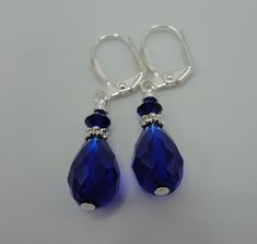 "Beautiful pair of sapphire blue crystal teardrop earrings! Faceted tear drop shaped crystals, sterling silver plated spacers and 4mm Swarovski crystals dangle from the sterling silver plated lever back ear wire. These earrings dangle approximately 7/8\" from the base of the lever back ear wire. Such a beautiful color!" Blue Teardrop Crystal Earrings With Ear Wire, Sapphire Crystal Teardrop Earrings, Blue Teardrop Crystal Earrings For Pierced Ears, Blue Crystal Teardrop Dangle Earrings, Blue Crystal Teardrop Earrings For Gifts, Blue Crystal Teardrop Earrings, Sapphire Teardrop Crystal Earrings, Blue Teardrop Crystal Earrings, Blue Pear-shaped Teardrop Earrings For Anniversary