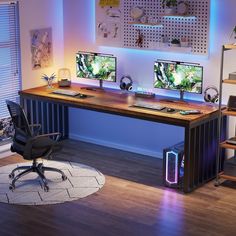 two computer monitors sitting on top of a wooden desk