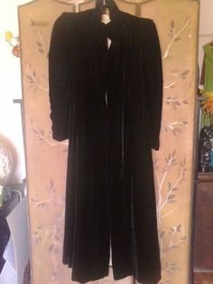 "Gorgeous ultra soft black velvet maxi cloak by Marshall Fields and company. Cloak has ruched stand up collar and the tops of shoulders have ruched pleats and sewn in shoulders pads which give the cloak a regal look. The sleeves come out from under the pleats. There are no fastenings or buttons, the cloak is maxi length. The lining is cream coloured silky fabric. Absolutely in almost unworn condition. The stand up collar has been mended at both front sides and may benefit from a professional sea Elegant Velvet Outerwear For Costume, Fitted Cape Outerwear For Costume Party, Fitted Cape For Costume Party, Black Velvet Costume Outerwear, Fitted Long Evening Outerwear, Fitted Long Outerwear For Evening, Black Long Evening Outerwear, Black Long Outerwear For Evening, Marshall Fields