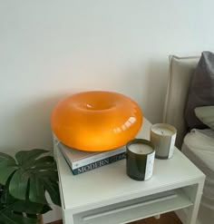 an inflatable donut sits on top of two candles next to a stack of books