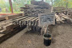 a bucket full of wood sitting next to a sign