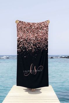 a black and pink beach towel with the name lauren & henry on it sitting on a dock