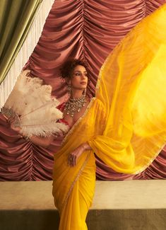 Wrap yourself in the sunshine hues of this stunning Yellow Organza Saree, perfect for making a statement at any festive event. The lightweight organza fabric drapes effortlessly, allowing you to move with grace while ensuring you’re the center of attention at any celebration. Paired with a beautifully embroidered red blouse, this saree is a showstopper for mehendi, sangeet, haldi ceremonies, or any wedding guest looking to add vibrant elegance to their look. Composition : Saree & Blouse - Georgette, Organza, Petticoat - Satin Lycra & Lining - Satin Care: Dry Clean Only and Vacuum Storage This product can be customized for sleeves, blouse length and neckline Delivery : 4-6 weeks as the product is hand crafted. Check Size Guide or choose MySize for free customisation (All Sizes above XL can Organza Blouse Piece For Diwali Reception, Organza Blouse Piece For Reception And Diwali, Organza Blouse With Cutdana For Reception, Silk Chiffon Party Pre-draped Saree, Festive Organza Saree Blouse, Diwali Organza Blouse With Traditional Drape, Traditional Drape Organza Blouse With Cutdana, Diwali Blouse In Organza With Traditional Drape, Traditional Drape Organza Blouse For Diwali