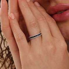 a close up of a person with a ring on their finger and her hand near her face