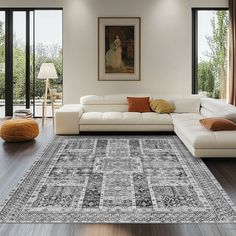 a living room filled with furniture and a large rug on top of a hard wood floor