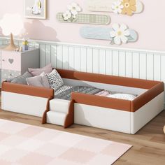 a child's bedroom with pink walls and white furniture, including a toddler bed