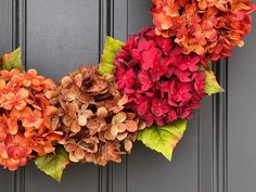 two wreaths with flowers are hanging on the door