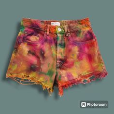 a pair of shorts with colorful paint all over the bottom and fraying on the sides