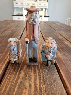 three gnome figurines sitting on top of a wooden table