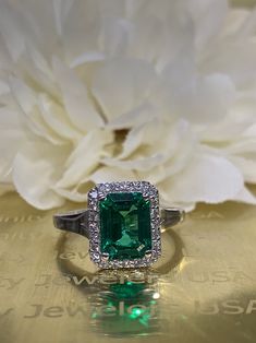 Emerald cut emerald engagement ring with diamond halo set in | Etsy 14k White Gold Emerald Ring With Brilliant Cut, Emerald Cut Green Diamond Ring With Prong Setting, Green Diamond Ring With Radiant Cut And Prong Setting, Green Emerald-cut Ring With Halo Design, Green Emerald Cut Ring With Halo Design, 14k White Gold Emerald Cut Halo Ring, Emerald Cut Emerald Ring With Halo Setting, Green Emerald Diamond Ring With Halo, Radiant Cut Emerald Diamond Ring With Center Stone