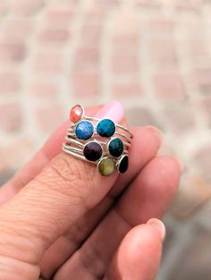 Discover the timeless elegance of our Sterling Silver Ring "EL SEMANARIO", a unique piece that combines craftsmanship and sophistication. This ring is composed of seven individual bands, each adorned with a circular, natural semi-precious gemstone, embodying a true rainbow of colors. The carefully selected gemstones - Moonstone, Lapis Lazuli, Spondylus (purple and orange), Malachite, Red Jasper, and Chrysocolla - add a touch of charm and mysticism to your style. Designed in France and crafted in Adjustable Sterling Silver Multi-stone Rings, Adjustable Multi-stone Round Band Jewelry, Adjustable Multi-stone Jewelry Band, Adjustable Multi-stone Sterling Silver Rings, Fusion Style Stackable Round Jewelry, Sterling Silver Stackable Rings With Natural Stones, Handmade Multicolor Fine Jewelry Rings, Fusion Style Stackable Round Rings, Fusion Style Stackable Round Rings As A Gift