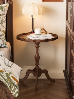 a small wooden table with a lamp on it