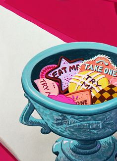 a blue bowl filled with lots of cookies on top of a white and pink table