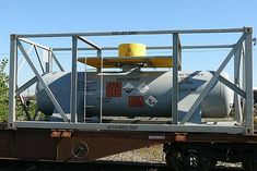 a train car sitting on the tracks with a large tank attached to it's side