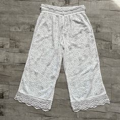 the white lace pants are on display in front of a wooden floor with wood planks