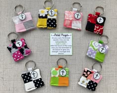 a group of small key chains with different designs on them, all in various colors