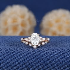 an engagement ring on top of a blue towel with fluffy white balls in the background