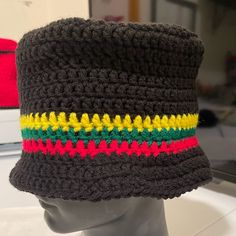 Crotchet Hat. Black W/(Red Green Gold/Yellow). Handmade. New. Acrylic. Stretchy. Unisex. One Size Fits Most. New Without Tags. White Hat Sold Separately. Black Brimmed Crochet Hat, One Size Fits Most, Yellow Cotton Beanie Hat, Black Knitted Brimmed Beanie, Black Brimmed Knitted Beanie, Black Crochet Bucket Hat One Size, Casual Black Crochet Hat, One Size, Black Crochet Beanie Hat, Black Yarn Cap, Black Crochet Cap Hat