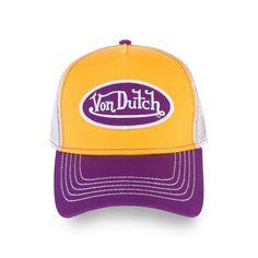 A classic snapback trucker hat by Von Dutch features purple and gold, with iconic logo patch on front, white breathable mesh rear, and an adjustable snapback panel. Purple and gold trucker cap Von Dutch logo patch Breathable mesh rear Curved bill Adjustable snapback panel One size fits most *ALL TRUCKER/HEADWEAR SALES Trucker Hat With Logo Patch And Curved Visor, Retro Trucker Hat With Embroidered Logo And Curved Bill, Mesh Trucker Hat With Logo Patch For Streetwear, Retro Snapback Trucker Hat For Sports, Retro Mesh Trucker Hat, Purple Snapback Trucker Hat, Retro Trucker Hat With Curved Visor For Baseball Season, Retro Trucker Hat With Curved Bill For Sports Events, Logo Trucker Hat With Curved Visor For Streetwear