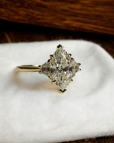 a diamond ring sitting on top of a white napkin