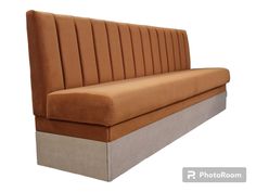 a brown and grey couch sitting on top of a white floor next to a wall