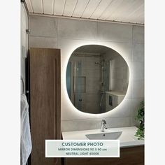 a bathroom with a large round mirror on the wall