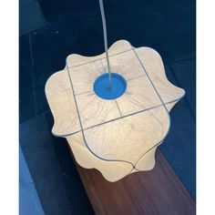 a lamp that is sitting on top of a wooden stand with a blue light in the middle