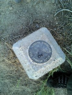 a man standing next to a stone with a plaque on it's side in the grass