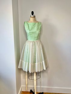 "1950s mint green and white fit & flare mini dress with textured polka dot overlay. This dress is so, so cute!! It is not a low back dress, the dress was a bit small on my mannequin and so is not fully zipped.  In very good vintage condition B: 32\" W: 25\" L:  31.5\"" 1950s Style Green A-line Dress, 1950s Style Sleeveless Green Dress, 1950s Style Green Lined Dress, Green Retro Dress With Full Skirt, Green Retro Full Skirt Dress, 1950s Style Green Vintage Dress For Spring, Vintage Green Dress With Full Skirt, 1950s Style Green Dress For Garden Party, 1950s Vintage Summer Dress