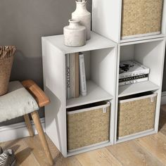 a white shelf with baskets and books on it