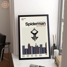 a spiderman movie poster hanging on the wall next to a desk with a chair