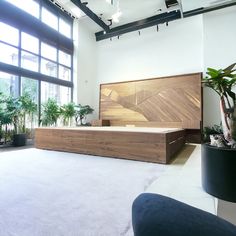 a large bed sitting in the middle of a room next to a plant filled wall