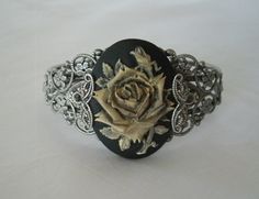 This beautiful silver plated filigree cuff bracelet has a rose cameo setting with silver plated filigree accents on the sides. Adjustable. Carved Adjustable Jewelry For Wedding, Unique Antique Silver Bracelet For Wedding, Victorian Engraved Cuff Bracelet For Gift, Adjustable Victorian Jewelry For Formal Occasions, Elegant Carved Bracelet, Elegant Carved Adjustable Bracelet, Antique Silver Bangle Jewelry Gift, Antique Silver Bangle Jewelry For Gift, Elegant Adjustable Carved Bracelet