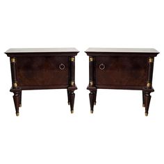 a pair of nightstands with marble top and brass trimming on the legs, each side by side