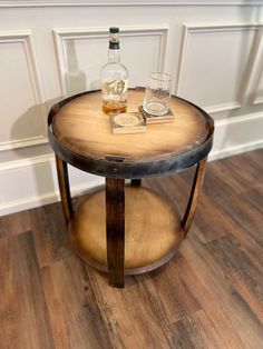 a wooden table with two glasses on it and a bottle sitting on top of it