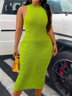 a woman standing in front of a car wearing a bright green dress and matching heels