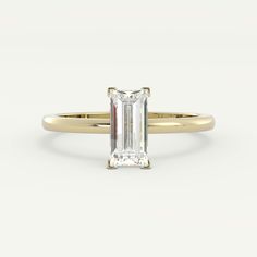 an emerald - cut diamond ring in yellow gold, set with a thin band on the side