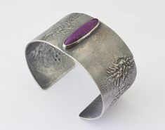 A very nice handmade cuff formed from 18 gauge Reticulation Silver.  The cuff is highlighted with a really nice Sugilite Gemstone.  The surface of the cuff has been oxidized and the oxidation partially removed to bring out the organic, dendritic nature of the surface. The cuff has an internal circumference of 7 inches which includes the gap of 1 inch. The bracelet is 1.3 inch wide. This would be a standard size bracelet that can be adjusted a bit. The Sugilite gemstone is natural and untreated. Mens Silver Cuff Bracelet, Gold Moonstone Ring, Womens Cuff Bracelets, Cuff Bracelets Handmade, Mens Cuff, Wide Cuff Bracelets, Unisex Bracelets, Sterling Silver Cuff, Silver Cuff Bracelet