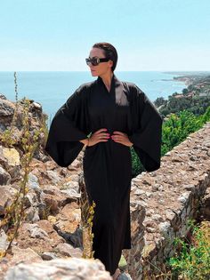 This gothic long kimono robe is a striking piece that blends dark elegance with luxurious comfort. Made from black satin, this kimono robe for women exudes a sense of sophistication and mystique, perfect for those who appreciate a gothic aesthetic. The bell-sleeve dress design adds a touch of drama and flair, enhancing the overall allure of the robe. Ideal as a gift for your wife, this elegant dressing gown is both practical and stylish, making it a cherished addition to her wardrobe.  ◌ SIZE: - Satin Kimono Dress, Satin Bathrobe, Elegant Dressing, Robe For Women, Dark Elegance, Satin Noir, Black Kimono, Satin Kimono, Dress Luxury