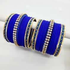 Bangle set comes with 2 sets - 1 per arm. Step into a realm of regal charm with our stunning royal blue bangles, accompanied by a captivating centre thread bangle adorned with diamond zircon stones. The deep and lustrous royal blue hue exudes a sense of grandeur and sophistication, making a bold statement wherever you go. The centre thread bangle adds a touch of artistry and delicacy, beautifully enhanced by the glistening diamond zircon stones, which add a mesmerizing sparkle to the ensemble. E Adjustable Hand Set Bangle For Celebration, Adjustable Hand-set Bangle For Celebrations, Traditional Adjustable Blue Jewelry, Blue Bangle Bracelet For Wedding, Blue Bangle Bracelets For Wedding, Blue Hand-set Bangle For Wedding, Blue Hand Set Bangle For Wedding, Blue Hand Set Jewelry For Festive Occasions, Traditional Blue Bracelets For Festivals