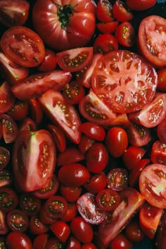 many tomatoes are shown together in this close up photo, with the top half sliced off